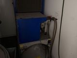a small room with a blue machine and a yellow trash can