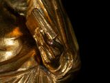 a gold statue of a woman holding a cell phone