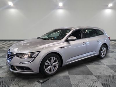 the silver car is parked on a checkered floor in the garage