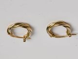 deux paires de boucles d'oreilles en or sur fond blanc