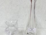 a glass vase and a glass candle holder on a table