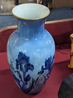 un vase bleu posé sur une table rouge, à côté d'autres objets