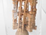 a wooden sculpture in a glass vase with a wooden ball