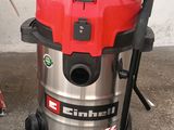 a red and black vacuum on the ground next to a red and black trash can