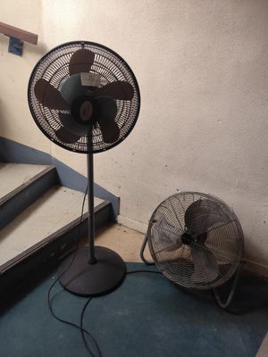 un ventilateur posé par terre à côté de l'escalier