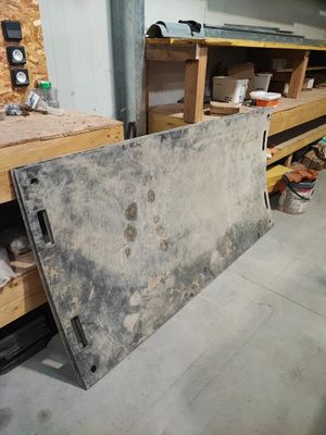 un gros morceau de métal posé par terre dans le garage