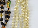 two strands of pearls and a bead necklace with a yellow and black bead