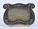 une radio vintage noire et dorée posée sur une table blanche