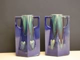 une paire de vases violets ornés de motifs verts et bleus
