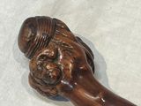 a wooden stick with a carved face on it