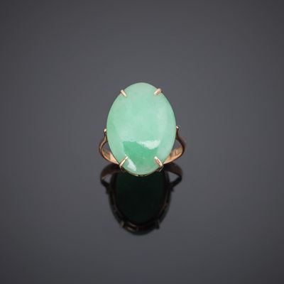 an oval green jade ring with a gold band