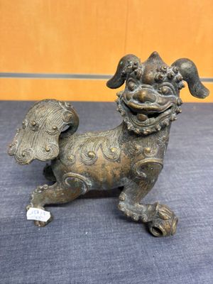 statue en bronze représentant un chien ailé sur un fond bleu