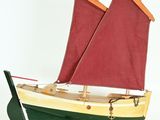 a model of a boat with red sails on a stand