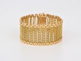 gros plan d'un bracelet en or sur fond blanc