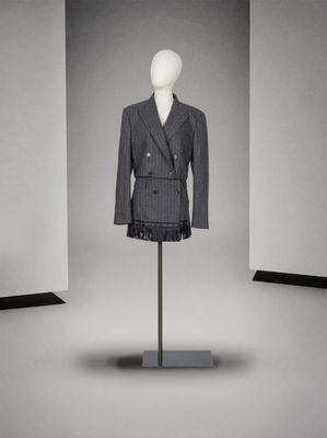 un mannequin vêtu d'un costume, exposé dans une pièce