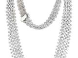 un collier blanc composé de trois rangées de perles argentées sur fond blanc
