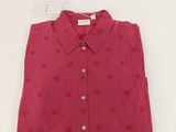 the shirt is red with hearts on it and has a button down collar