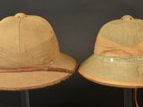 two hats are sitting on top of each other on a stand