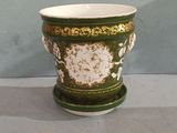 a green and white vase sitting on a table