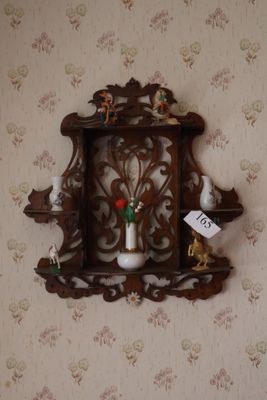 a wooden shelf with a vase on it on the wall