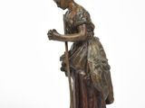statue en bronze représentant une femme avec une canne et un chien