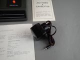 a small black device sitting on top of a table next to a piece of paper