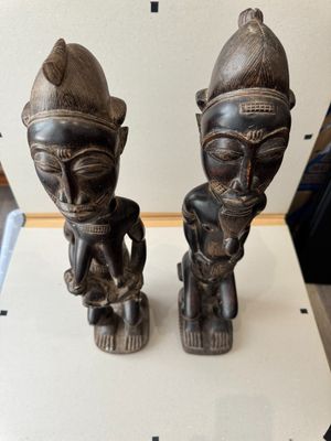 two wooden statues that are sitting on a table