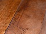 close up of a wooden table with a metal plate on top of it