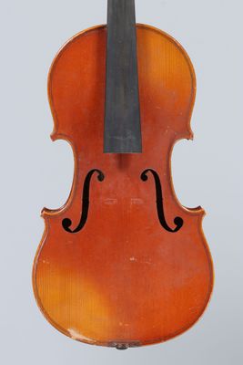 un vieux violon posé sur un chevalet, sur une surface blanche