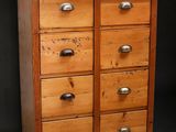 an image of a wooden chest of drawers against a black background