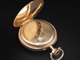 a gold pocket watch sitting on a black surface