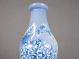 a blue vase with white flowers on it on a table
