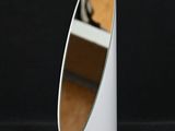 un miroir blanc posé sur un pied, sur fond noir