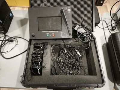 un ordinateur portable et d'autres appareils électroniques rangés dans une mallette posée sur une table