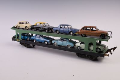 un petit train avec des wagons posés dessus, posé sur une surface blanche