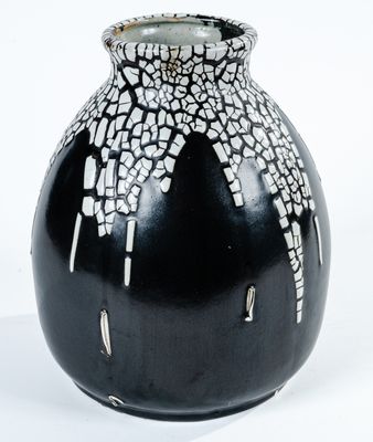 un vase noir orné de motifs blancs et noirs
