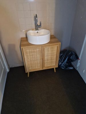 une salle de bains équipée d'un lavabo et d'un meuble de rangement
