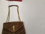 brown sued handbag with chain strap and a red purse