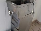 an image of a kitchen with a sink and a trash can