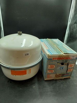 un grand pot blanc posé à côté d'une pile de livres