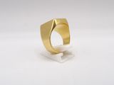 a close up of a gold ring on a white surface