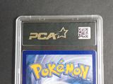 a pokemon card in a plastic case on a table