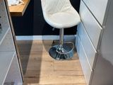 une chaise blanche placée devant un bureau sur lequel se trouve un ordinateur