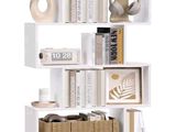 a white book shelf with baskets and books on it