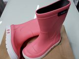 une paire de bottes de pluie roses posée sur une boîte