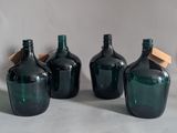 three green glass bottles with wooden lids sitting on a table