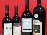 several bottles of wine are lined up on a wooden table