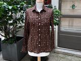 une chemise marron posée sur un mannequin devant un immeuble