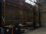 a large warehouse with a lot of scaffolding on the roof