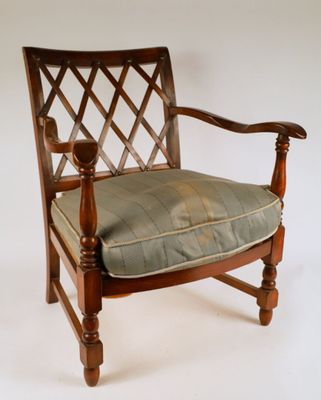 une chaise en bois sur laquelle est posé un coussin vert